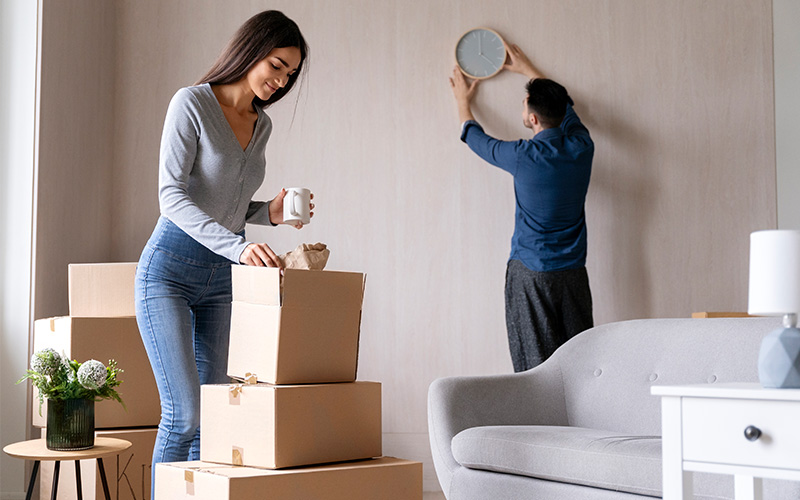 Couple performing essential cleaning and organizing tasks while moving house.