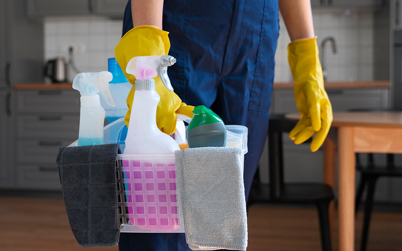 Professional cleaner carrying supplies for a scheduled home cleaning
