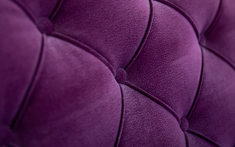 Close up of tufted purple velvet upholstery needing professional cleaning