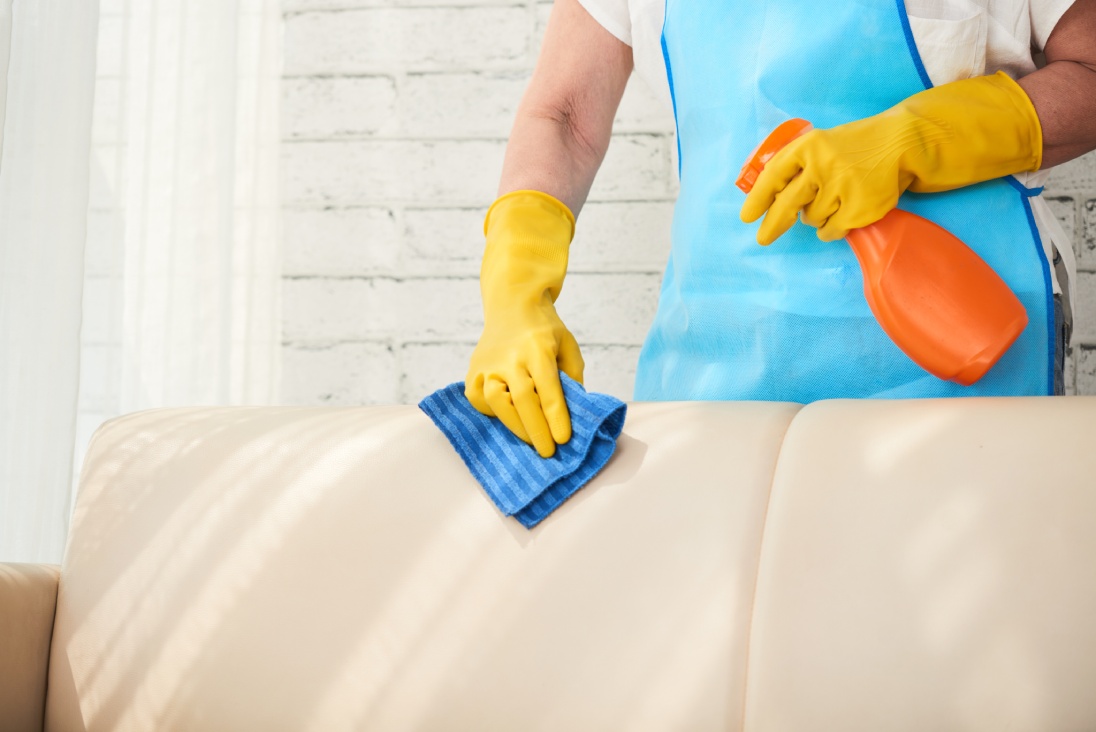 Housekeeper wiping dirty sofa